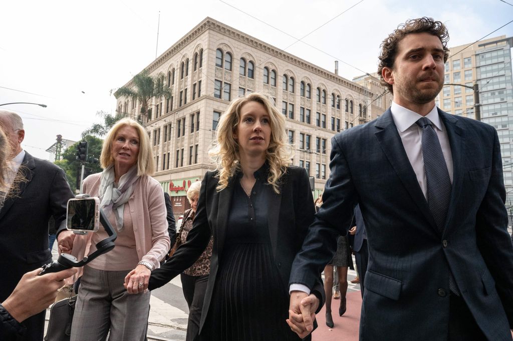 Elizabeth Holmes, founder and former CEO of blood testing and life sciences company Theranos, walks with her mother Noel Holmes and partner Billy Evans into the federal courthouse for her sentencing hearing on November 18, 2022 in San Jose, California.