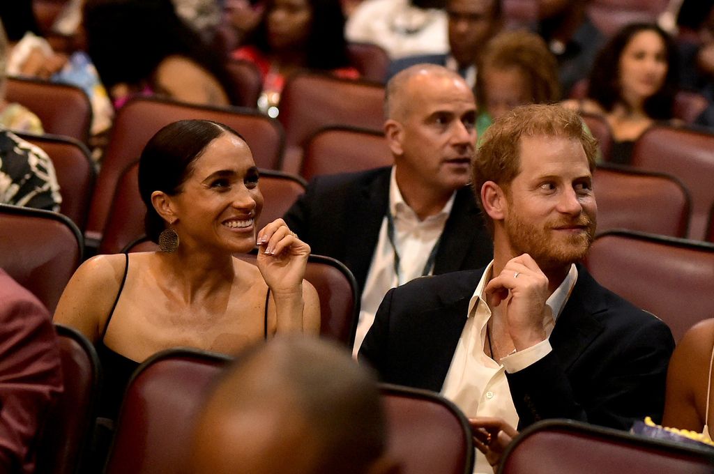 Prince Harry and Meghan Markle smiling in cinema seats