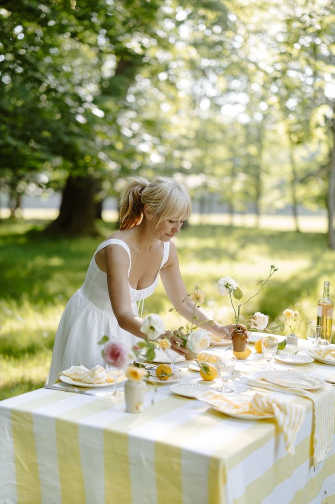 woman dressing a table outside