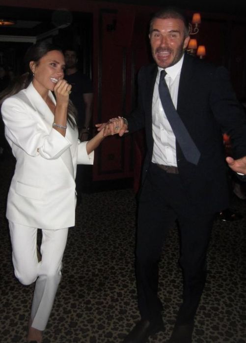David and Victoria Beckham holding hands and smiling