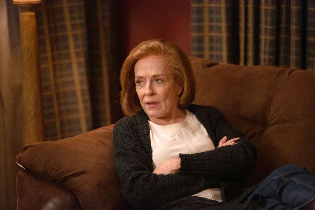 woman with arms folded sitting on sofa