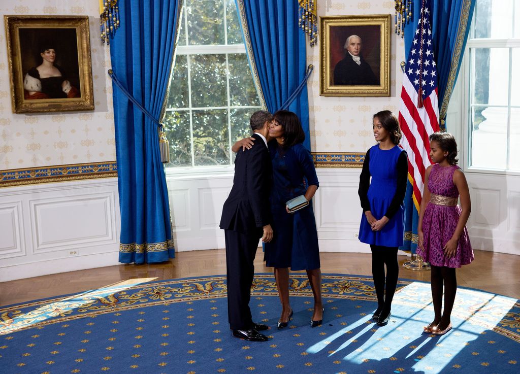 U.S President Barack Obama hugs the first lady Michelle Obama (2nd L) as daughters Malia (C) and Sasha look on after taking the oath of office in the Blue Room of the White House January 20, 2013 in Washington, DC. Obama and U.S. Vice President Joe Biden were officially sworn in a day before the ceremonial inaugural swearing-in.