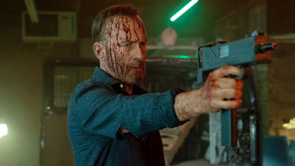 Bob Odenkirk points a gun at someone off screen in still from Nobody 2