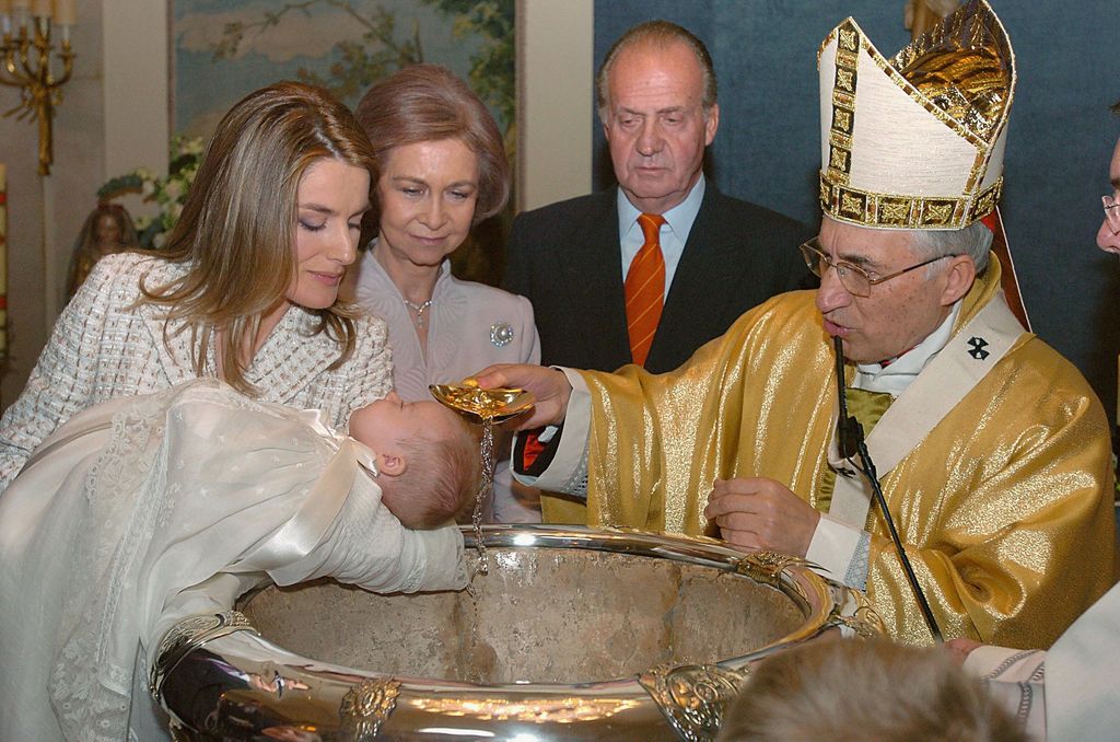 Princess Leonor getting chistened - Queen Letizia holds her while Queen Sofia and King Juan Carlos look on