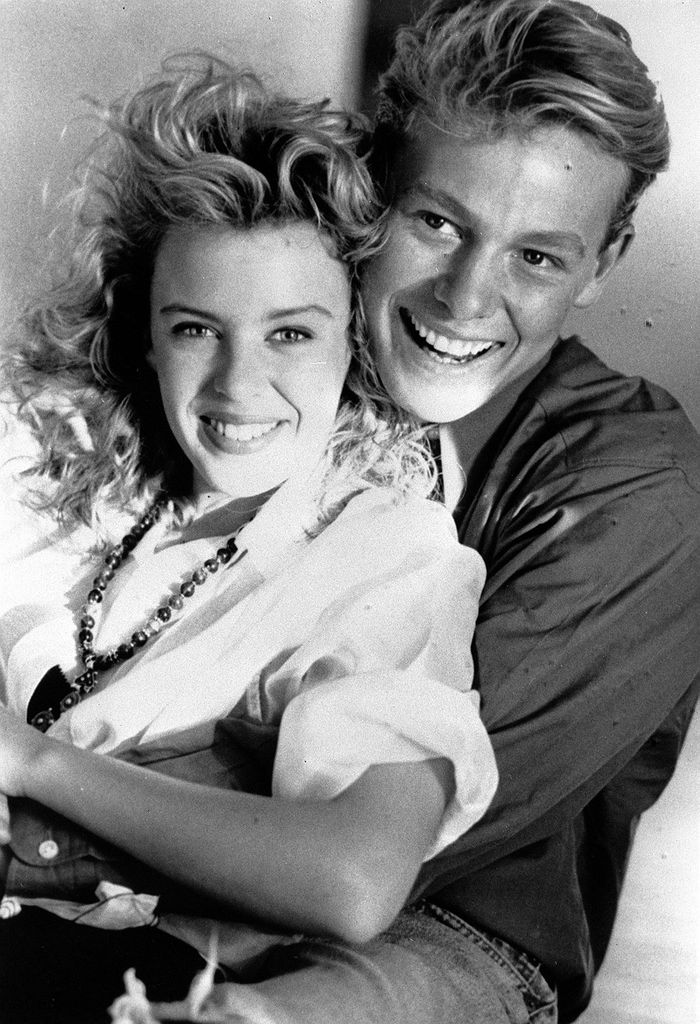 A black-and-white photo of Jason Donovan hugging Kylie Minogue