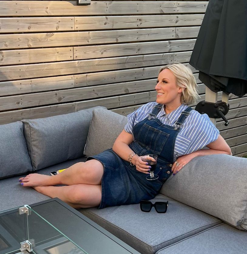 Steph McGovern on a sofa in a dungaree dress