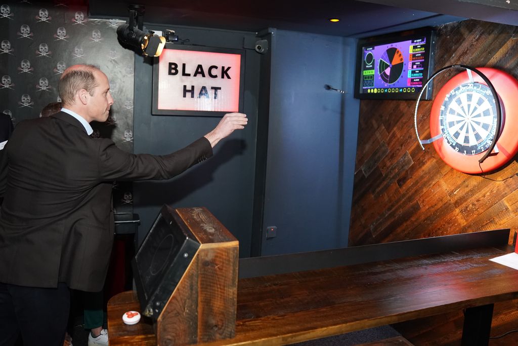 The Prince of Wales tries his hand at interactive darts in the 180 Club