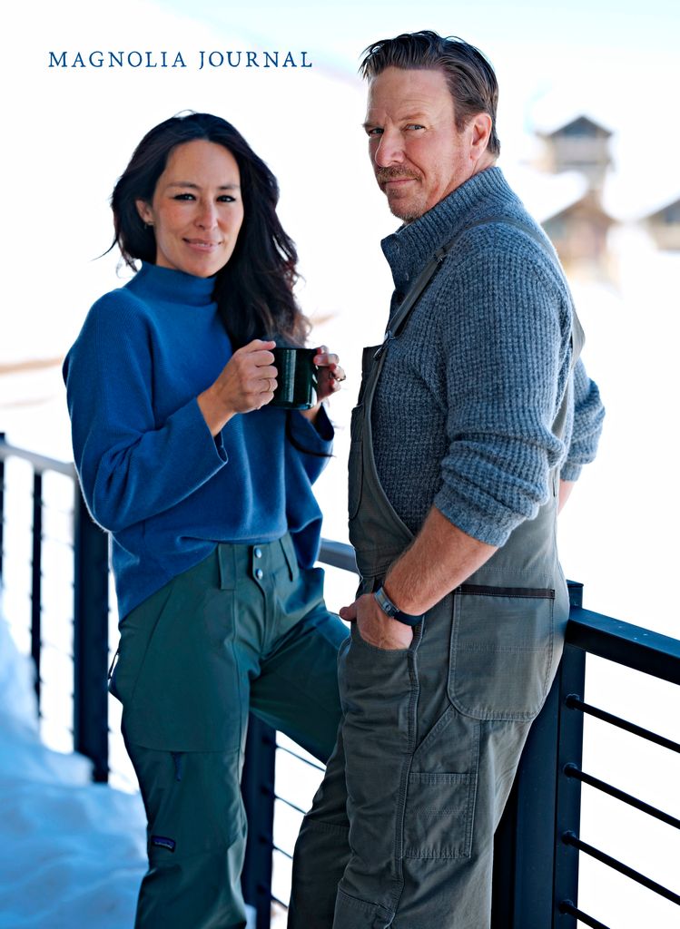Joanna and Chip Gaines stand outside on a balcony surrounded by snow