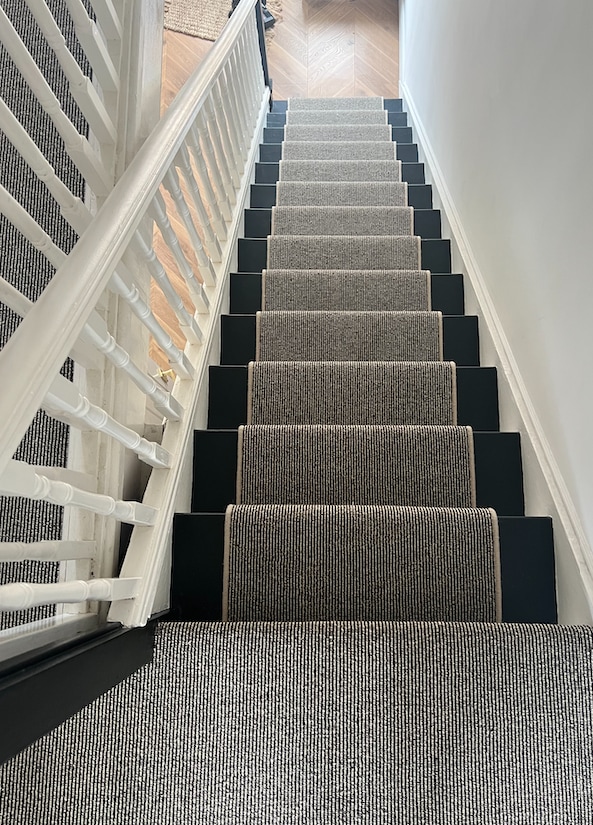 view from top of stairs with stair runner