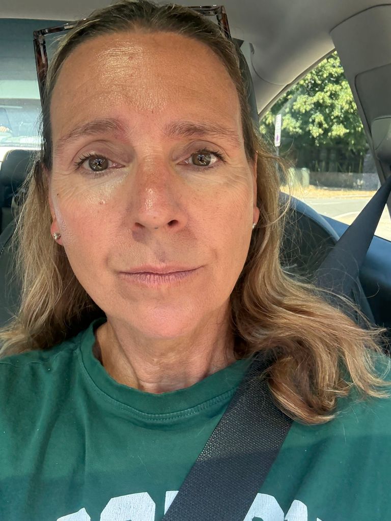 Midlife woman smiling in a green top 
