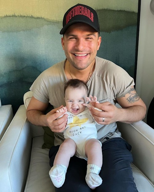 father holding baby and smiling 