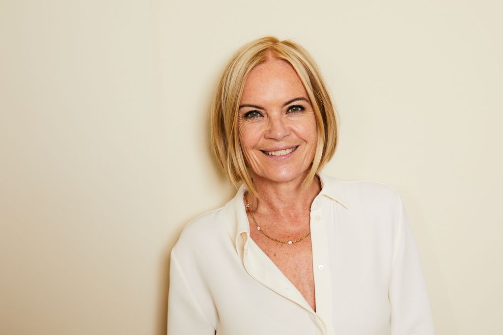 woman with blonde bob smiling in a white shirt 
