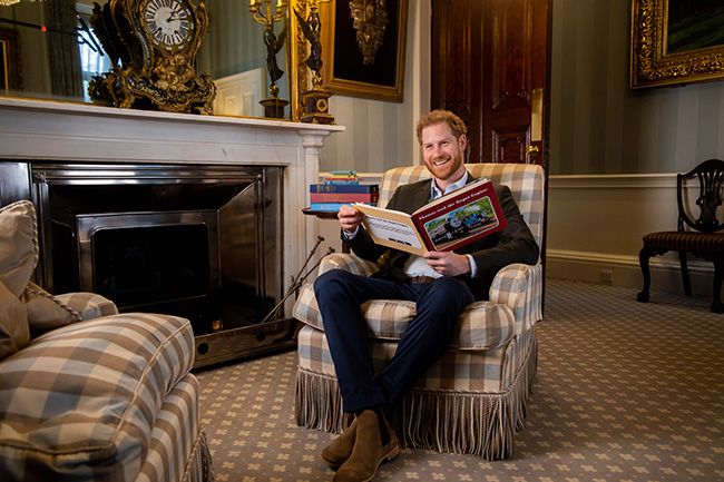 prince harry smiling reading book