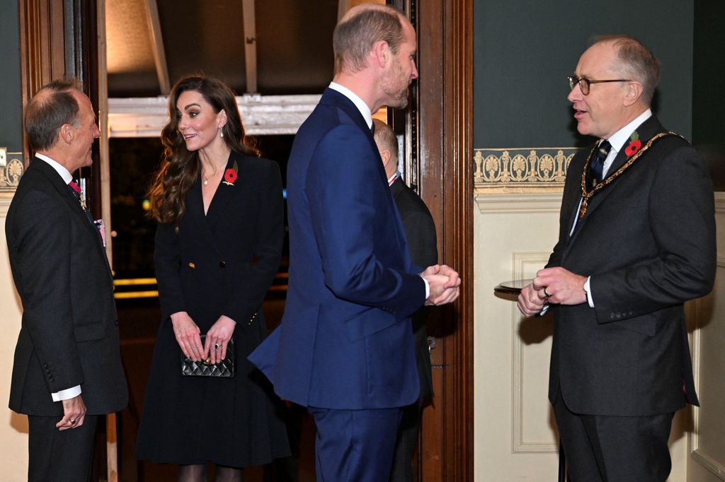 Kate Middleton and Prince William talking to men in suits