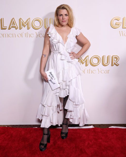 busy philipps posing on a red carpet in a white frilly dress