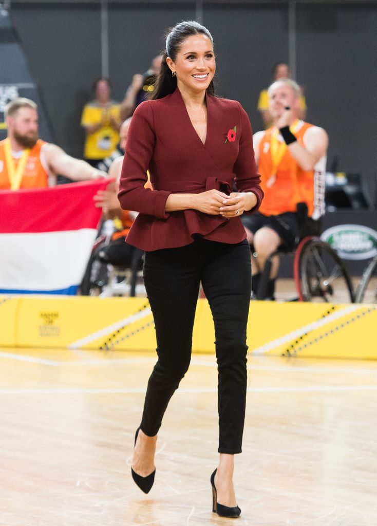 Meghan, Duchess of Sussex in black skinny jeans and crimson top