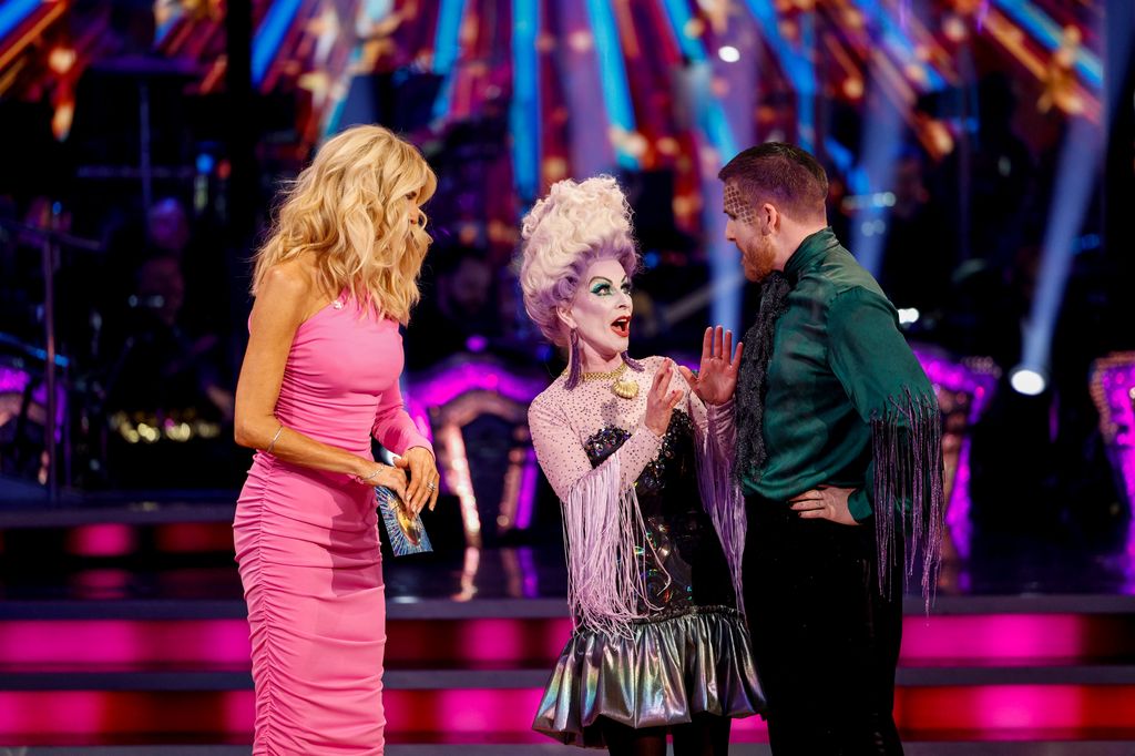 two dancers on dance floor chatting to host