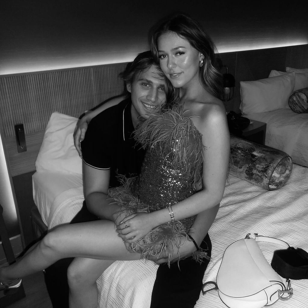 Jaden Agassi and his girlfriend sitting on a bed in black and white