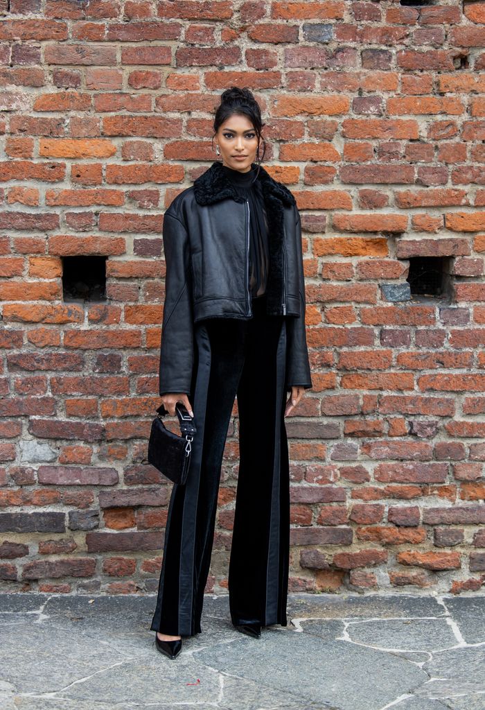 MILAN, ITALY - SEPTEMBER 20: Pritika Swarup wears black shearling leather jacket, two tone striped pants, bag outside Alberta Ferretti during the Milan Fashion Week - Womenswear Spring/Summer 2024 on September 20, 2023 in Milan, Italy. (Photo by Christian Vierig/Getty Images)