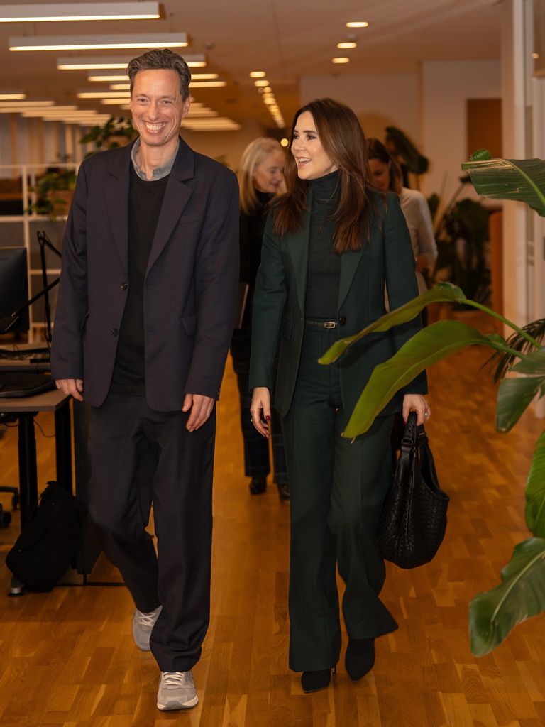 Queen Mary walking in room with man 