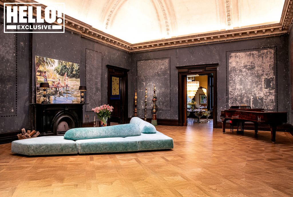 Living room with black walls and a blue velvet sofa