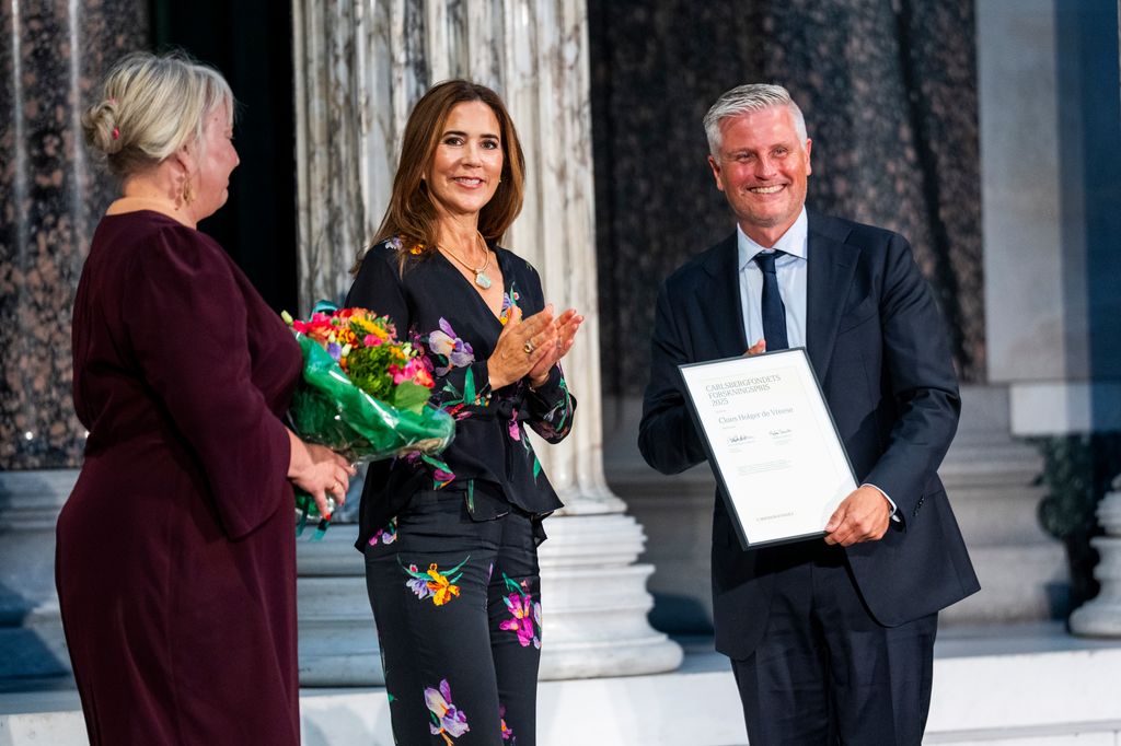 Minister of Education and Research Christina Egelund, and Queen Mary of Denmark present award winner Claes Holger de Vreese on stage during the Carlsberg Foundation's Research Awards
