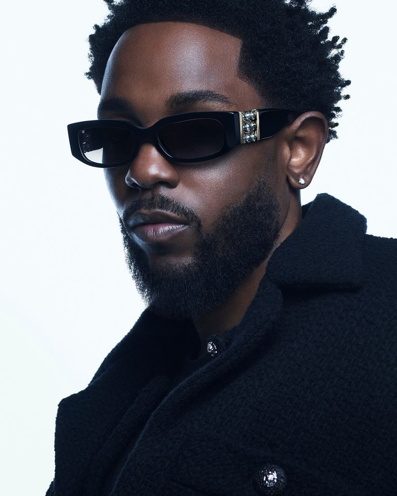 Kendrick Lamar wearing sunglasses looking towards the camera
