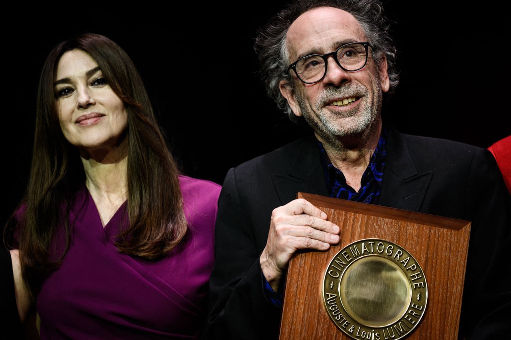 Tim Burton reacts as he receives the Lumiere Award from Italian actress Monica Bellucci during the awards ceremony of the 14th edition of the Lumiere Film Festival in Lyon, central-eastern France, on October 21, 2022.