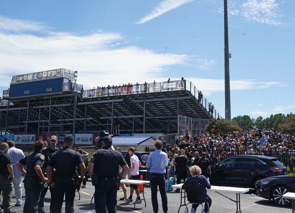 Law enforcement works at the scene as students wait to be picked up by their parents after a shooting at Apalachee High School on September 4, 2024 in Winder, Georgia. Multiple fatalities and injuries have been reported and a suspect is in custody according to authorities