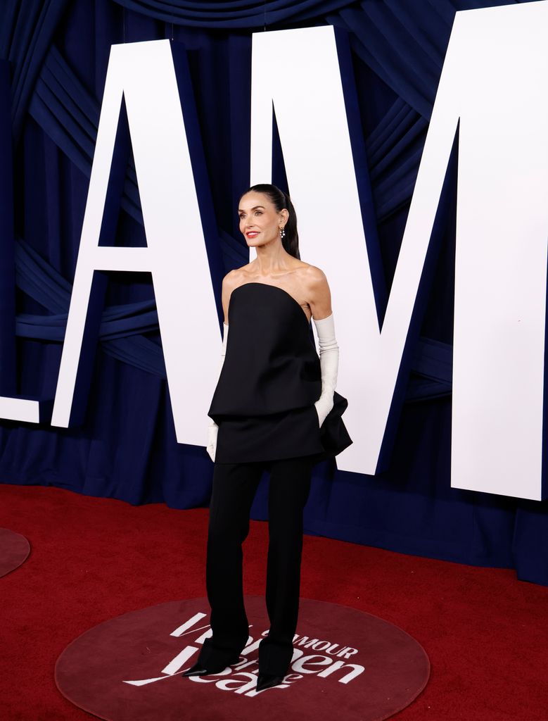 photo of demi moore with hair in a ponytail and wearing white opera gloves