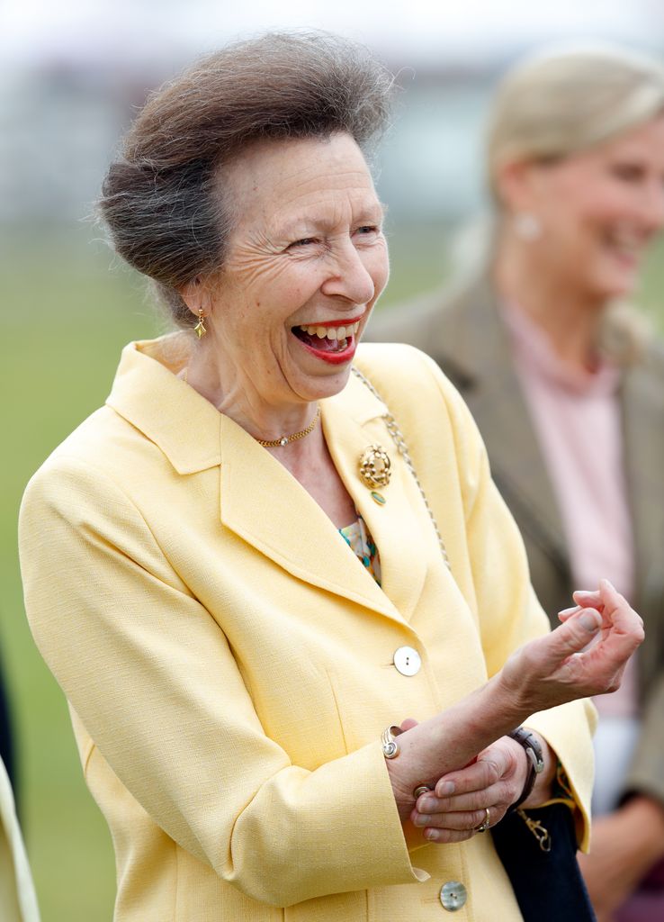 Princess Anne laughing in a yellow jacket