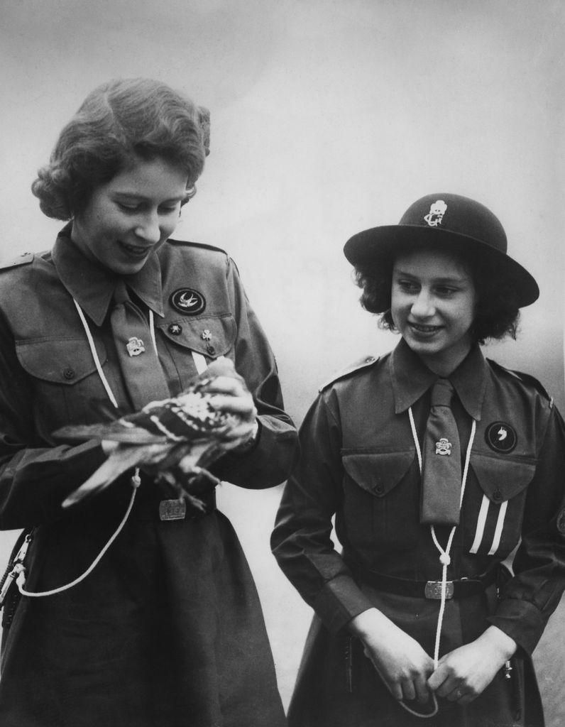 Black-and-white photo of the Queen and Princess Margaret with a pigeon