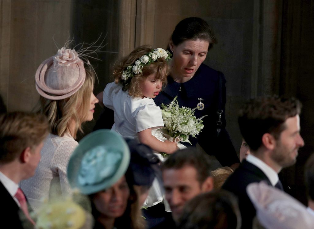 Royal Nanny Maria Teresa Turrion Borrallo comforts bridesmaid Zalie Warren inside the entrance to the chapel before the wedding of Prince Harry to Meghan Markle