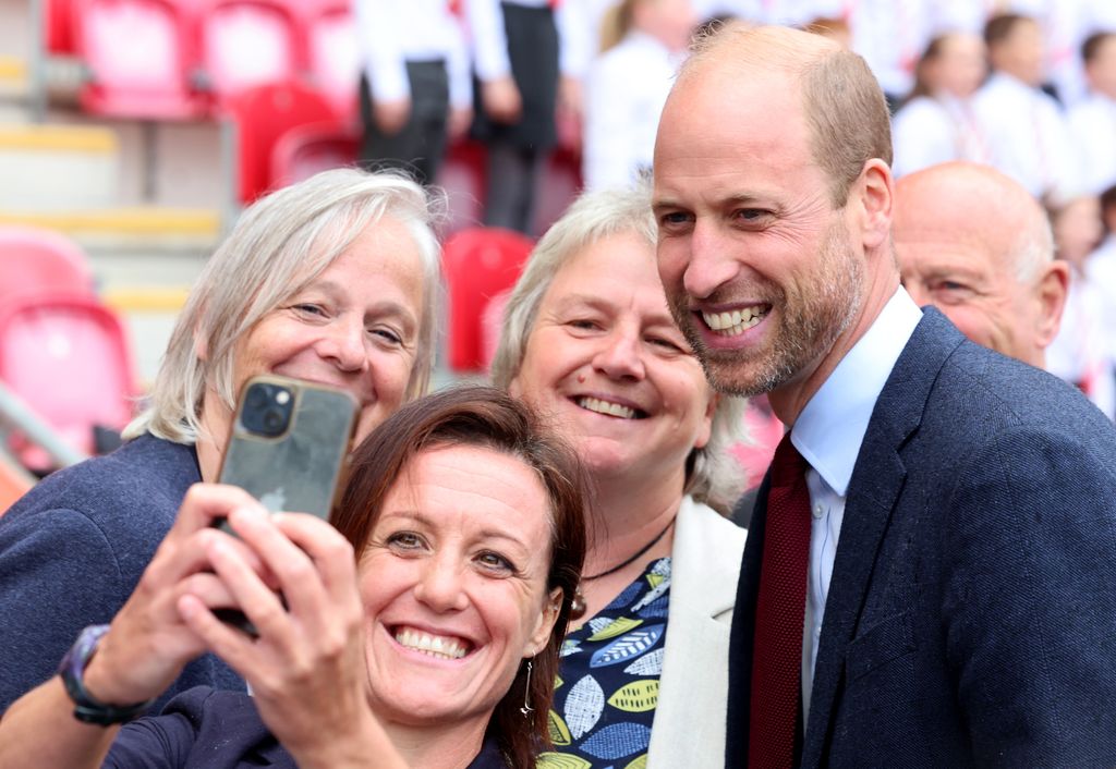 Prince William smiles for a photograph during for a visit to Parc y Scarlets