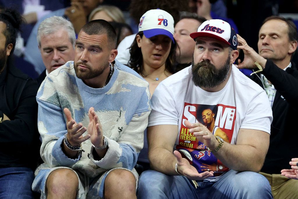 Travis Kelce of the Kansas City Chiefs and Jason Kelce of the Philadelphia Eagles watch game six of the Eastern Conference Semifinals in the 2023 NBA Playoffs 
