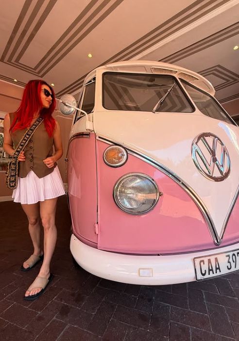 Dianne Buswell posing next to a pink campervan