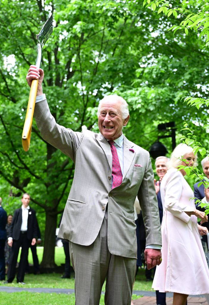 King Charles holding a shovel in the air