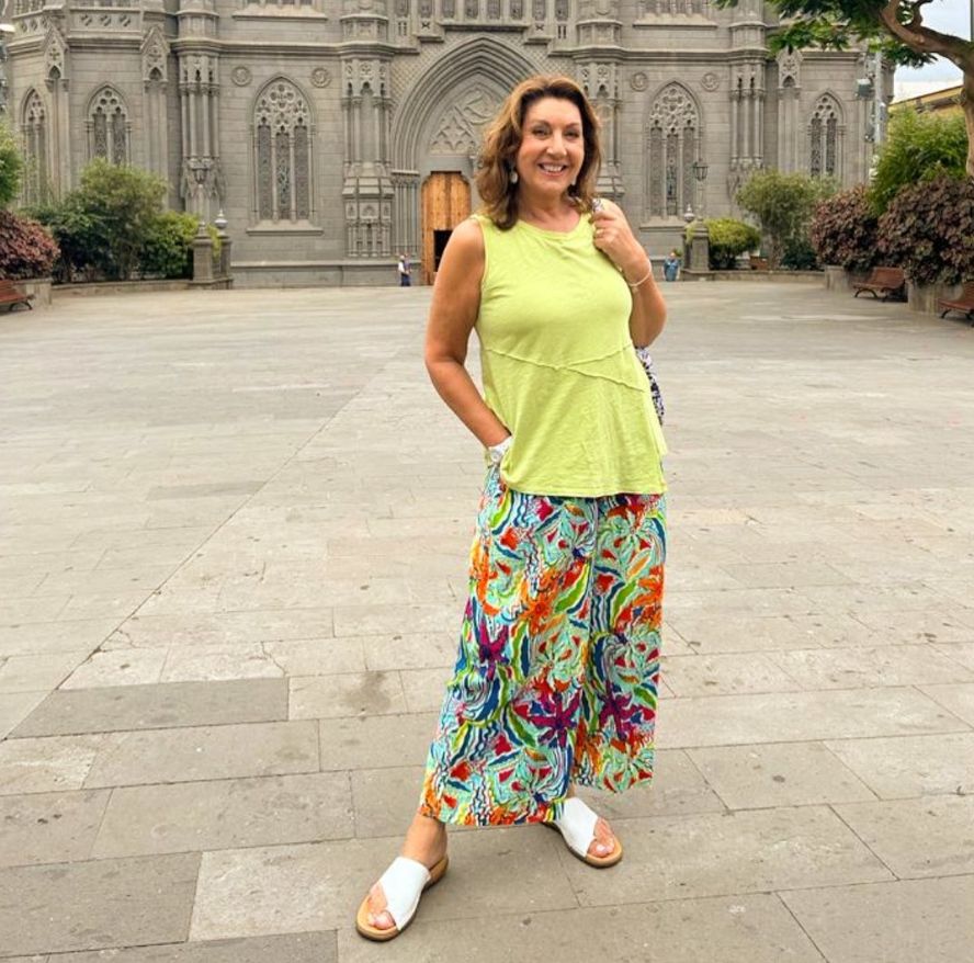 Jane McDonald in bright outfit in front of stone building