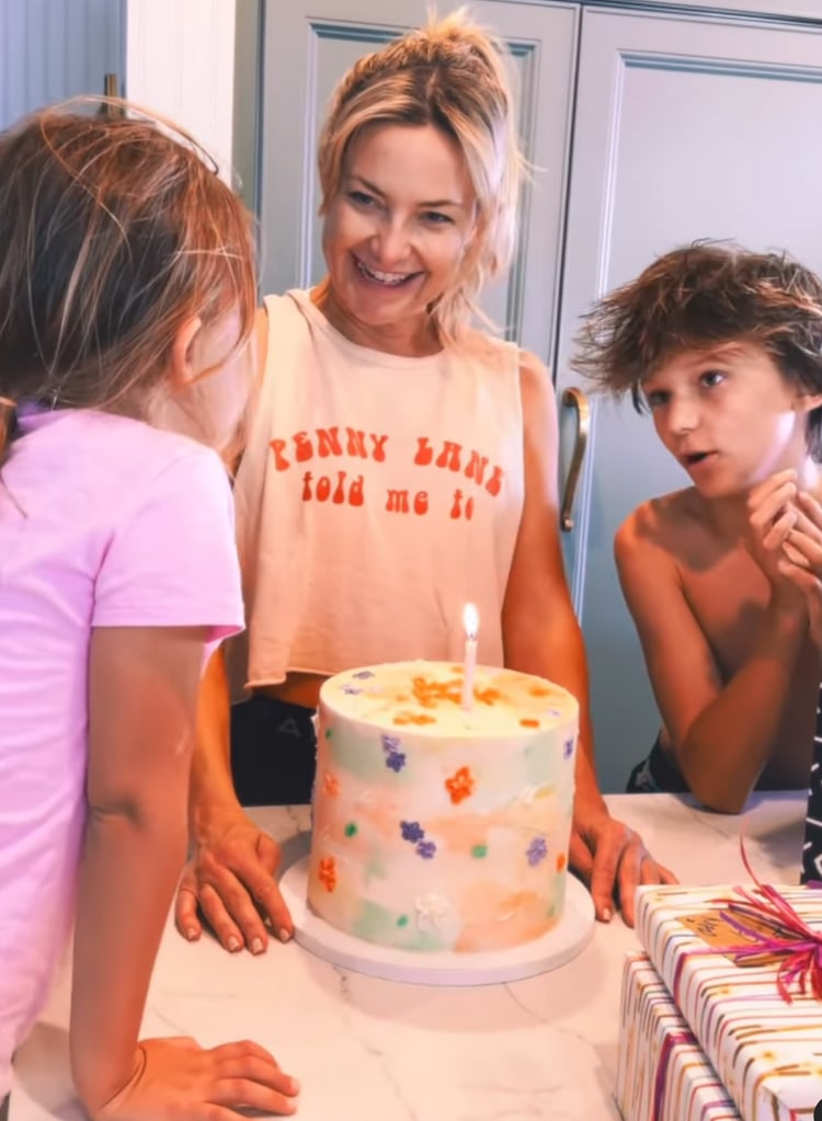 Clip from a video shared by Kate Hudson to Instagram on April 19, 2024 from her birthday celebrations, which sees her with a birthday cake in front and her kids Bing and Rani next to her