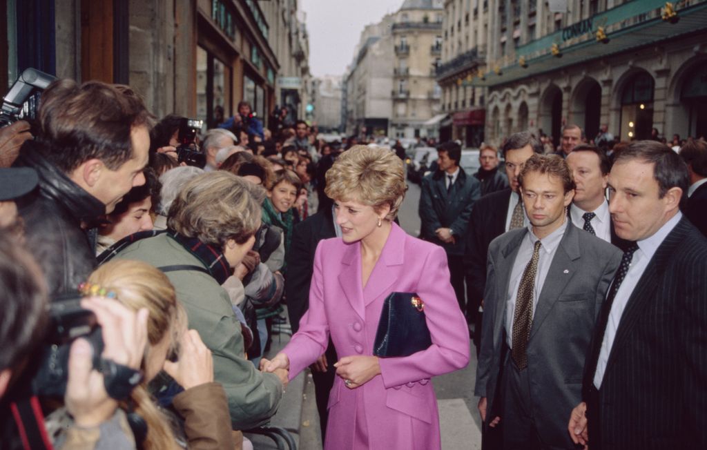 Princess Diana shaking hands with people while in Paris