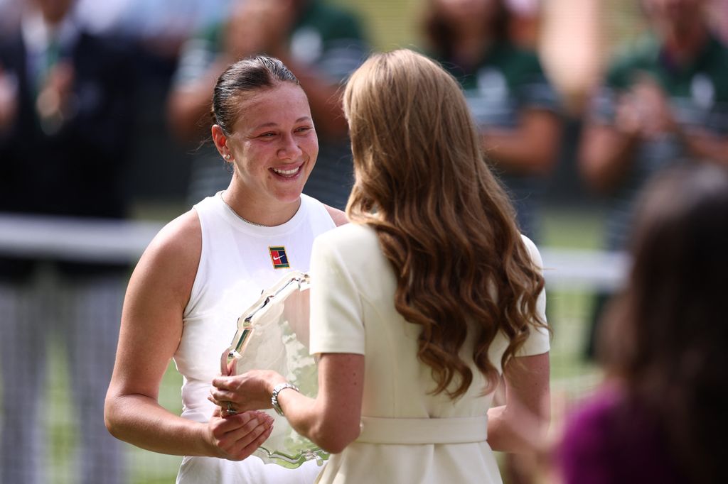Britain's Catherine, Princess of Wales gives the runner up trophy, to US player Amanda Anisimova after her defeat against Poland's Iga Swiatek at the end of their women's singles final tennis match on the thirteenth day of the 2025 Wimbledon Championships 