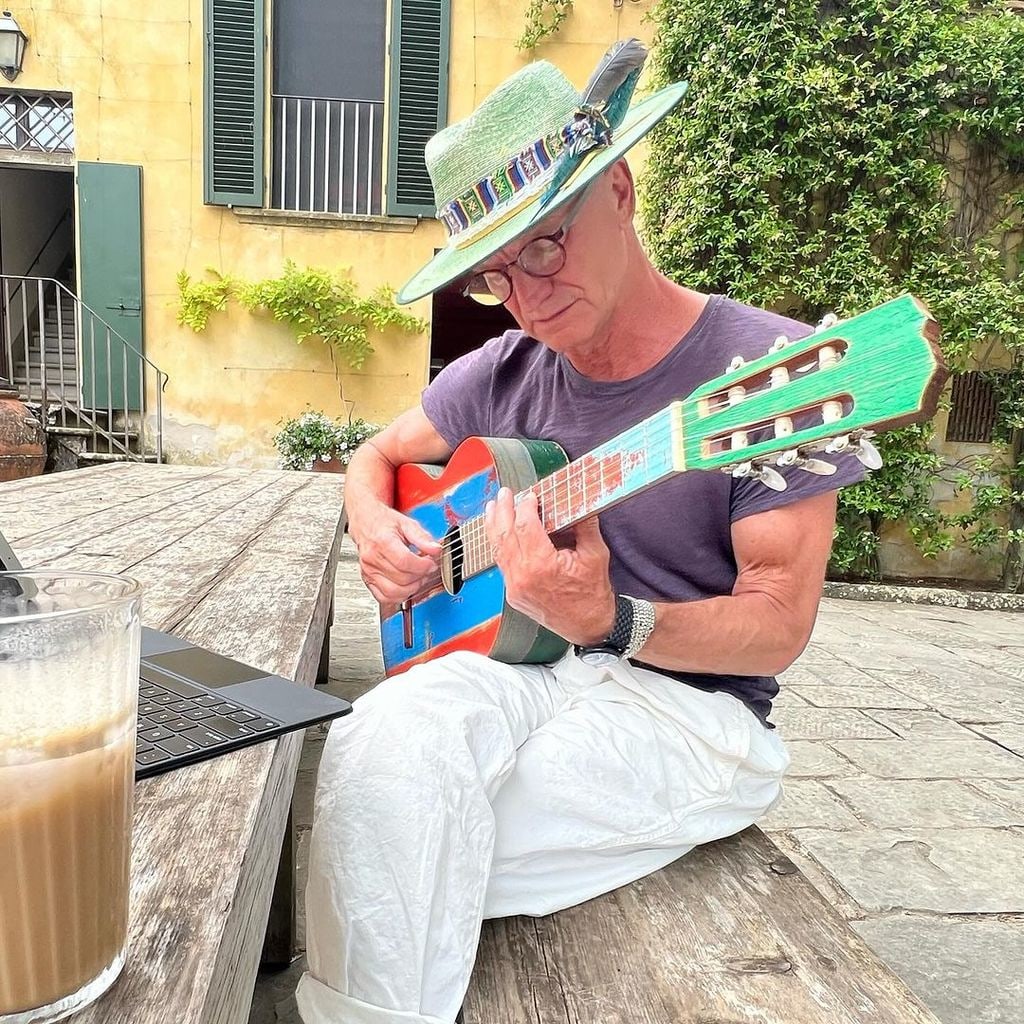 Sting plays guitar while sitting outside at Italian villa