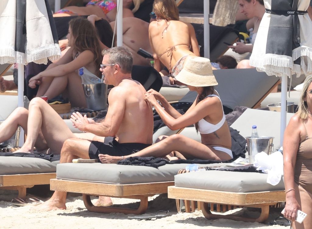 Matt Damon's wife Luciana Barroso applies SPF to his back as they sit on sun loungers