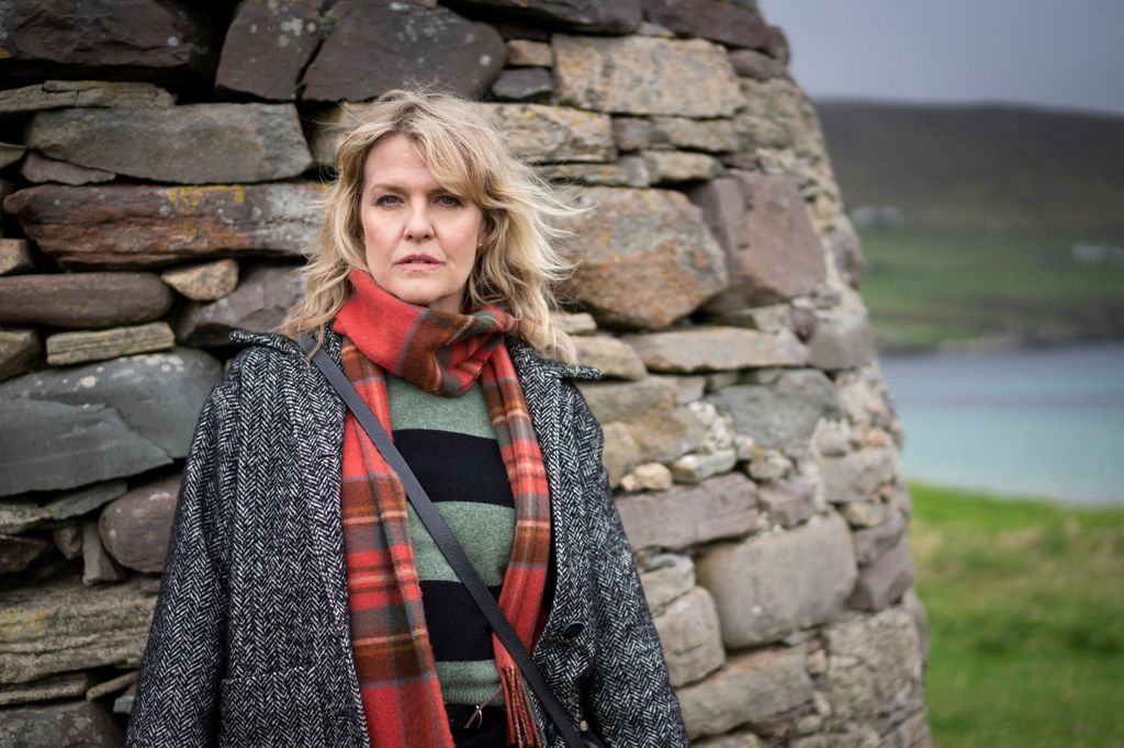 woman standing against wall of rocks