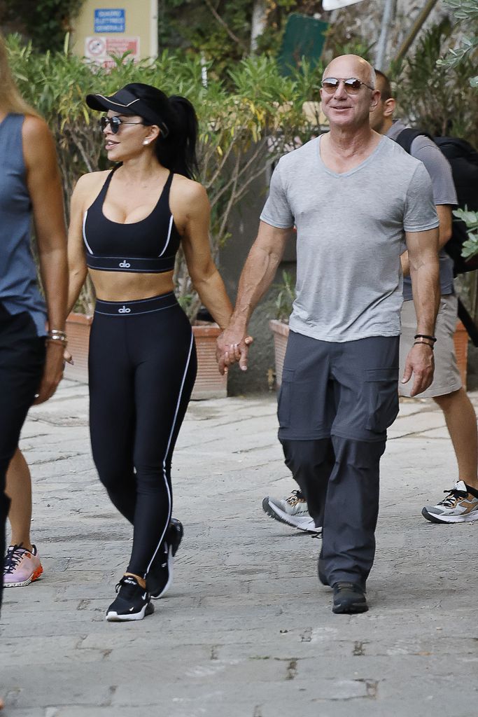 Lauren Sanchez and Jeff Bezos holdings hands and walking