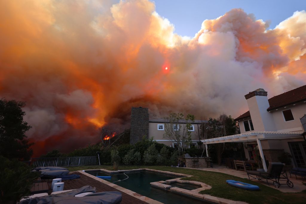 A brush fire burns near homes in Pacific Palisades, California on January 7, 2025