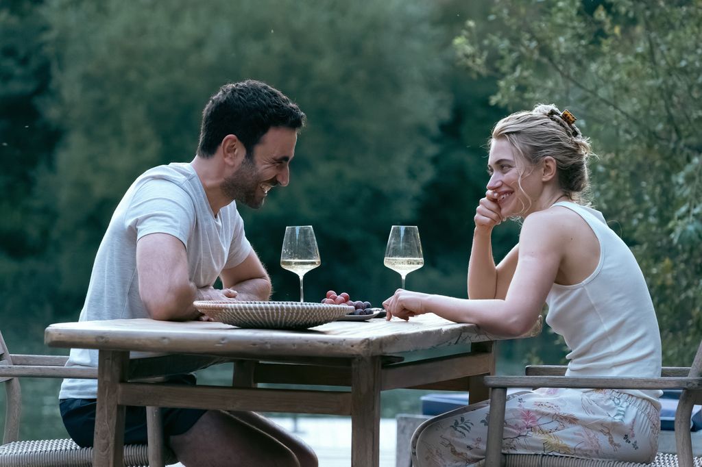 Brett Goldstein and Imogen Poots sitting across the table from each other drinking white wine in All for You