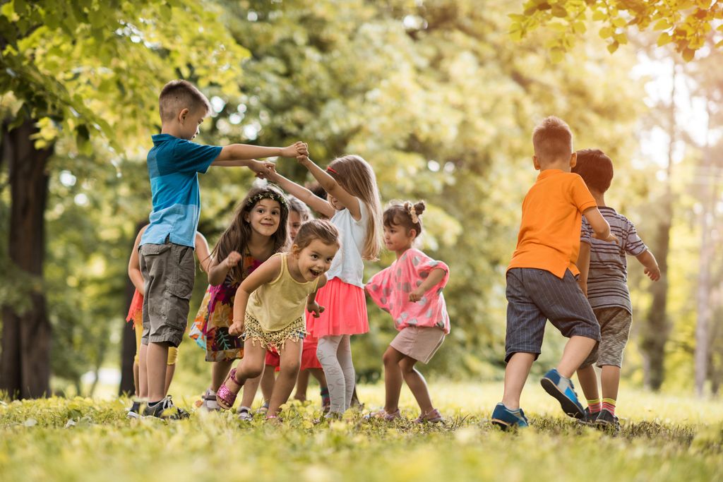 Group of happy little children having fun in the park.