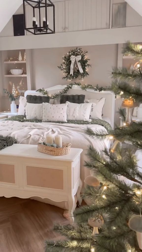 White bedroom decorated with festive bedding and a christmas tree