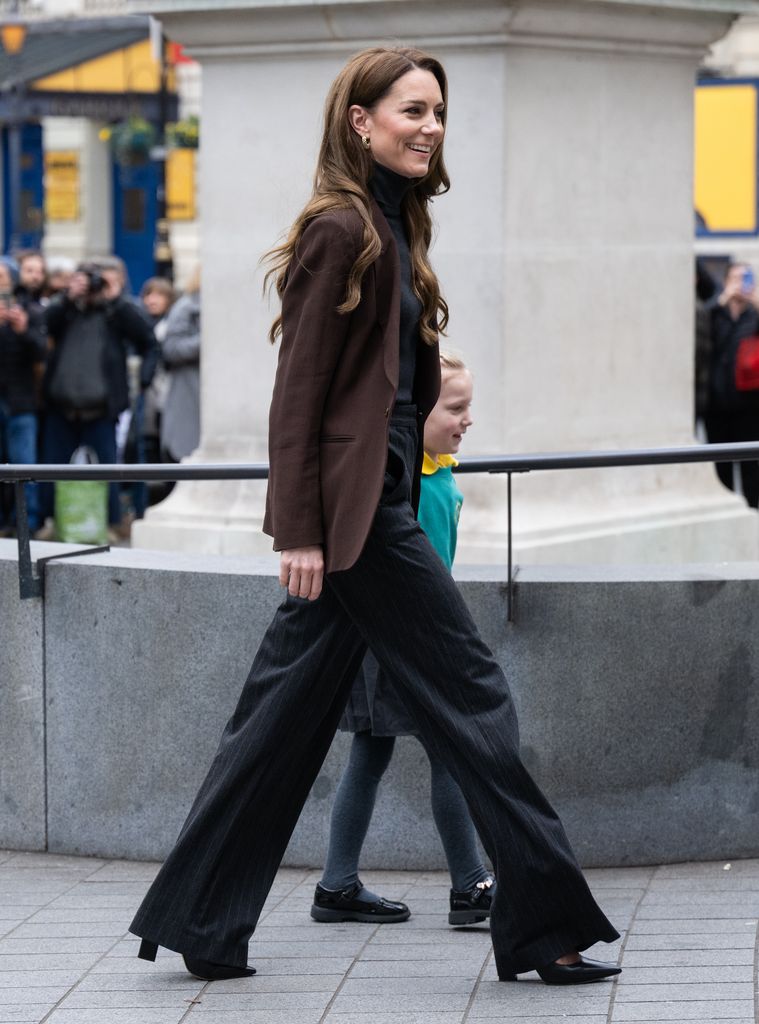 woman walking to gallery holding child's hand